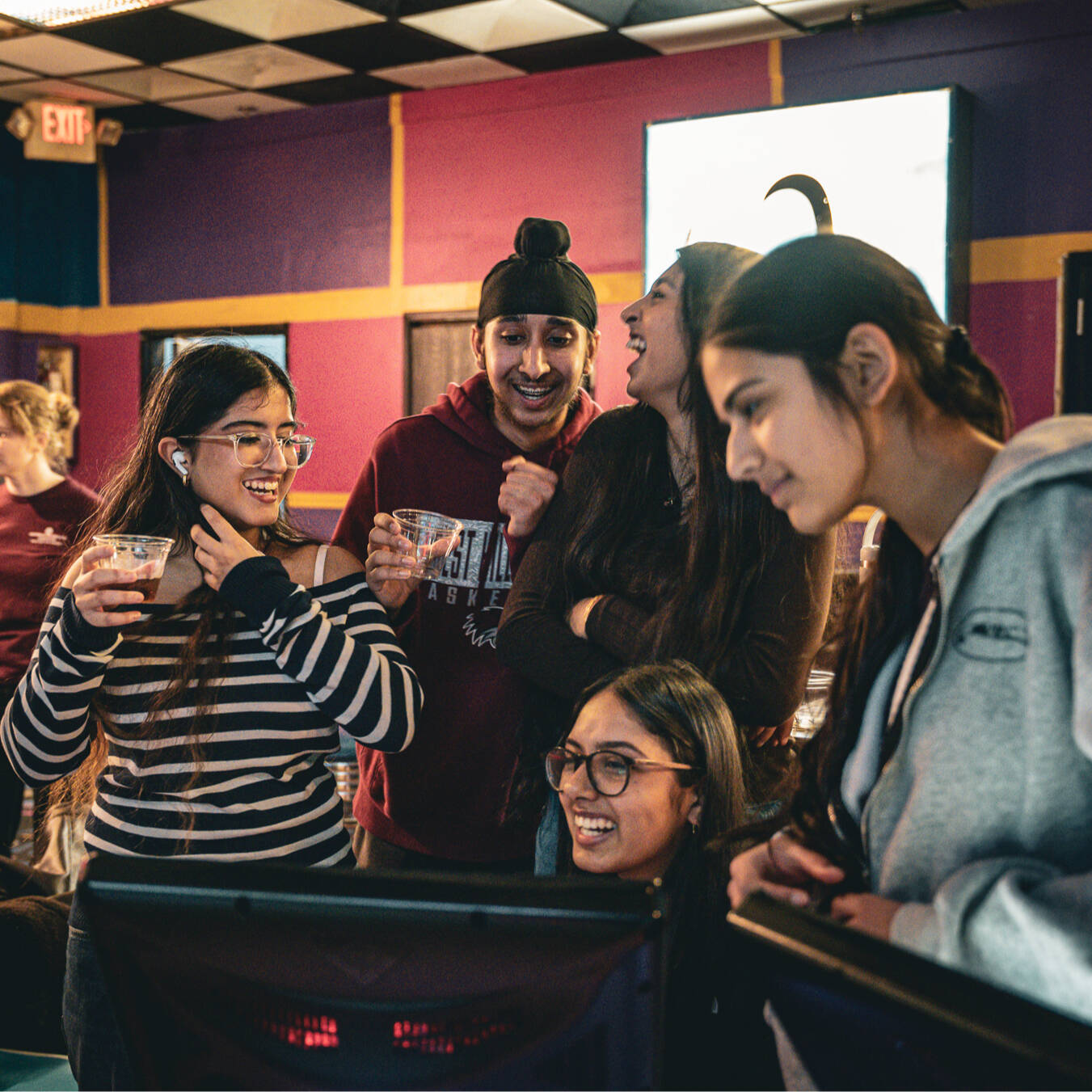 A group of 5 students laughing.